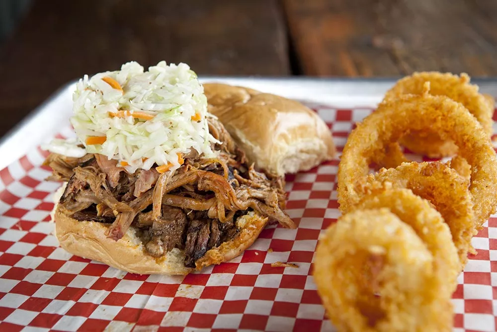 sam-_-erna-pulled-pork-and-brisket-sandwich-with-colelslaw-and-onion-rings.webp