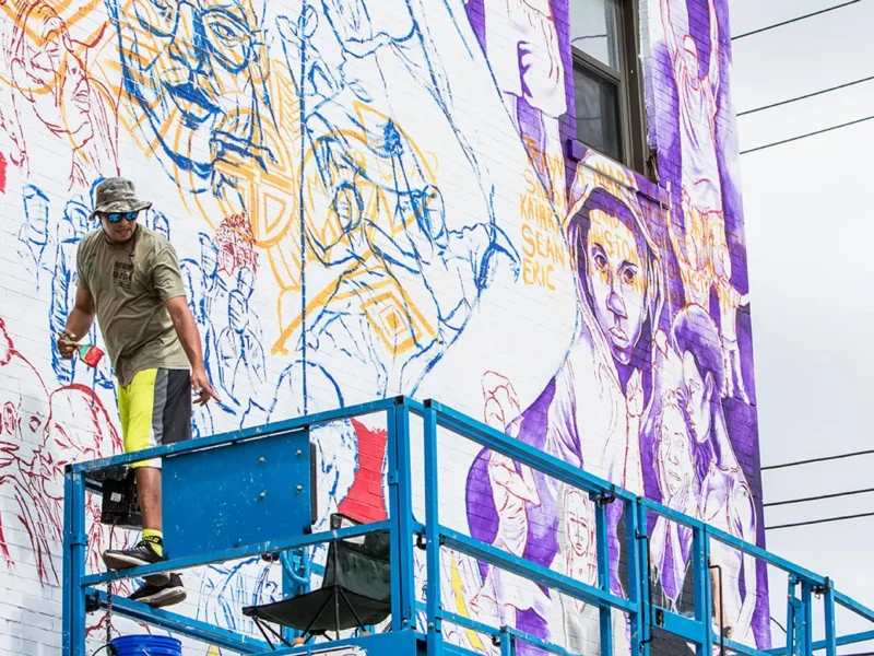 Kids work on a mural project in Homewood