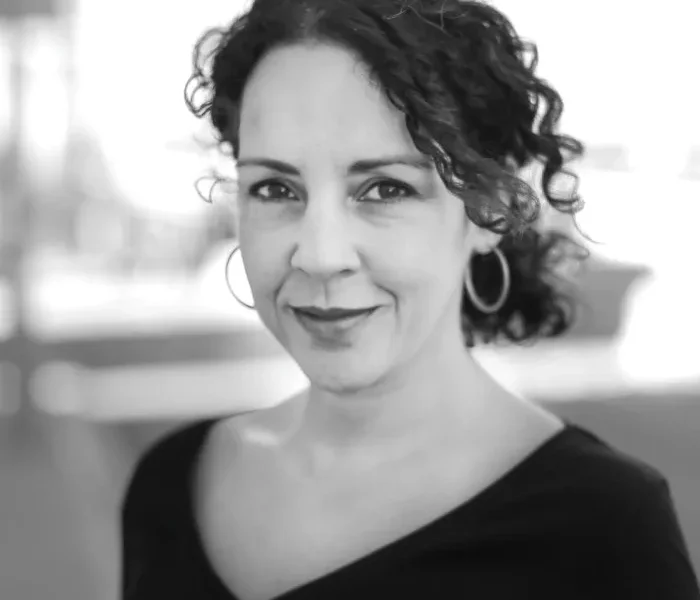 Black-and-white photo of a woman looking at the camera and slightly smiling