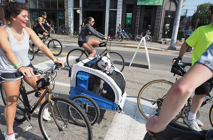 People bike on a street in Pittsburgh.