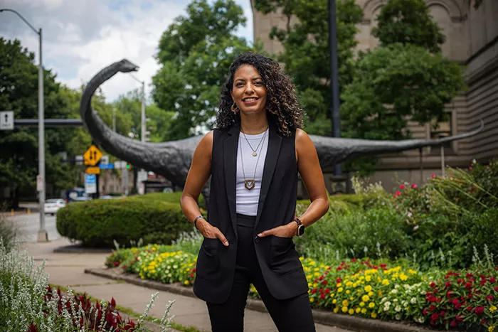A woman stands in front of a garden