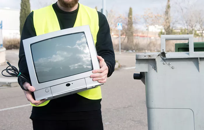 A person holds an old cathode-ray tube television.