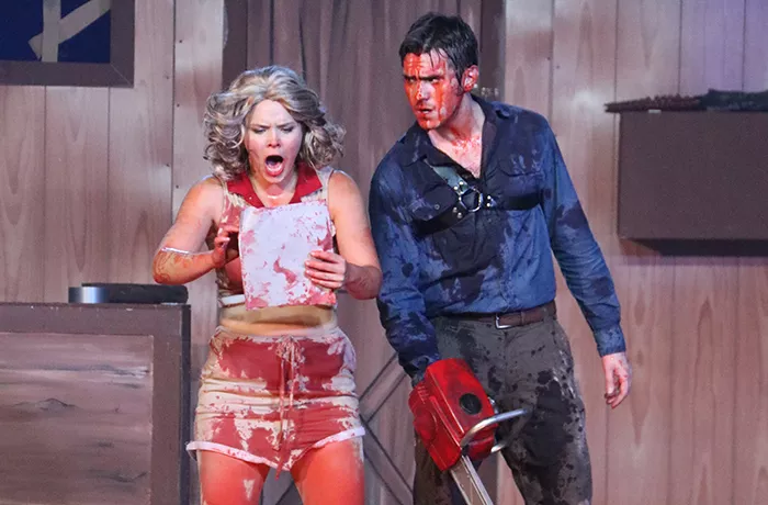 Two actors covered in fake blood on stage for Evil Dead the Musical