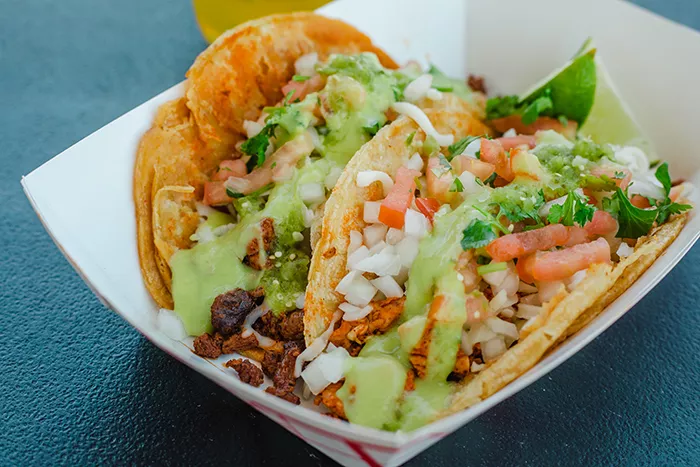 Two tacos in a paper tray.