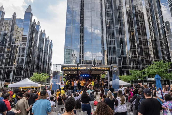 A crowd of people gather around a stage at PPG Place in Pittsburgh