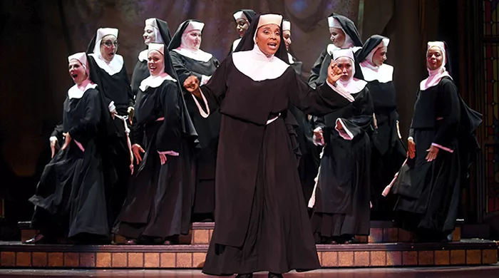 A group of nuns stand together, joyfully singing