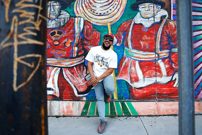 Man stands in front of mural