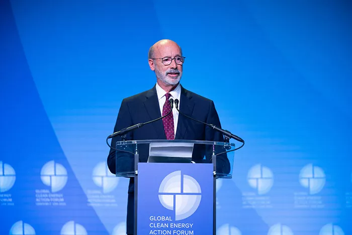 Pennsylvania Governor Tom Wolf speaking in front of a podium that says "Global Clean Energy Action Forum"