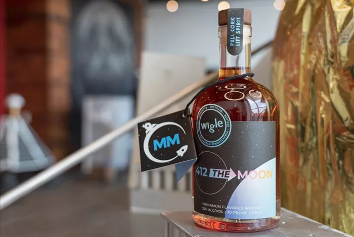 A bottle of whiskey sits in a clean, open space.