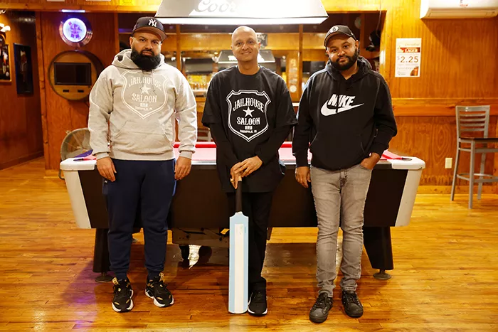 Three men stand together