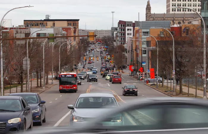 Four lane street filled with cars and busses