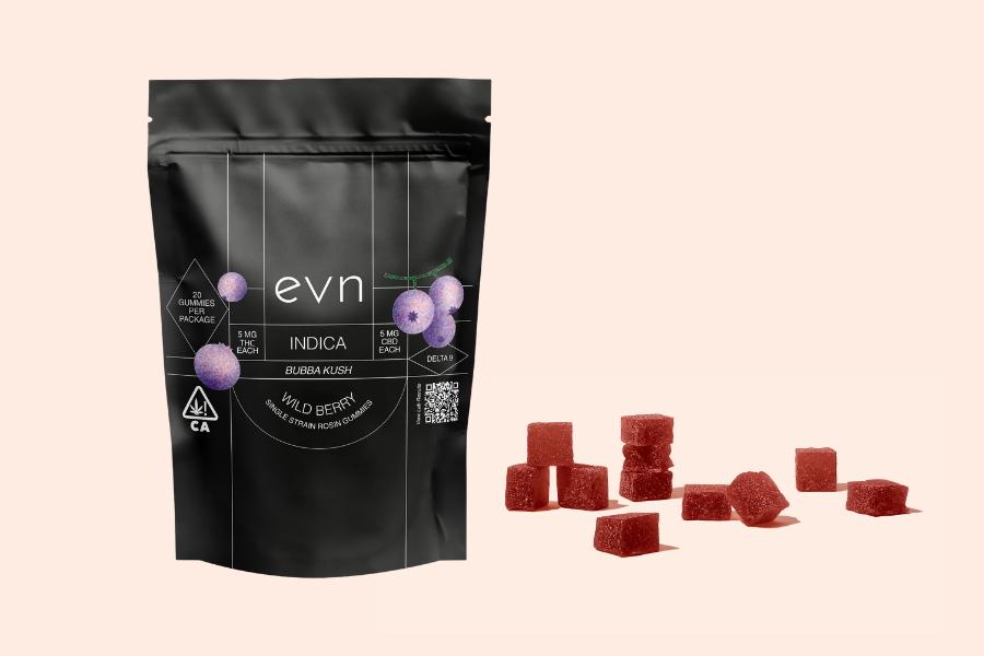 Pale pink background, image of black bag labeled 