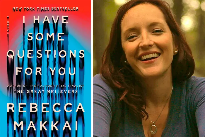 A woman with long brown hair, a blue V-neck shirt, and silver pendant smiles widely for the camera.