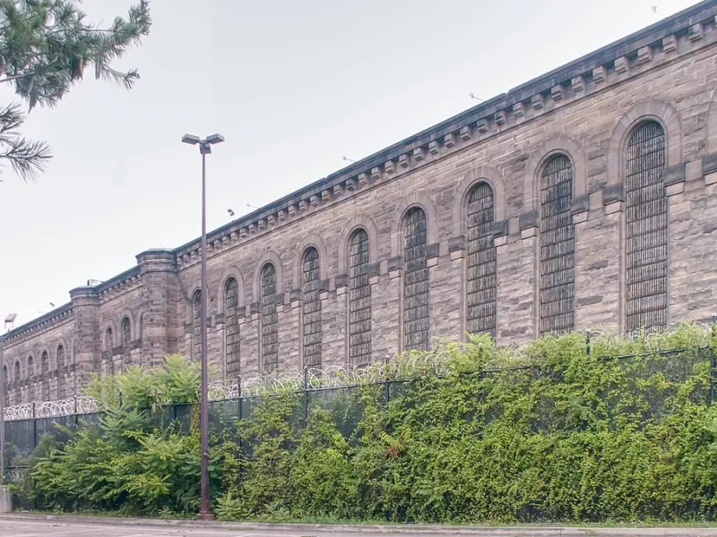 A long Romanesque building with barred windows and soot-stained walls