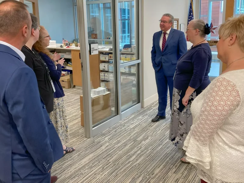 Three election officials in formalwear chat in an office