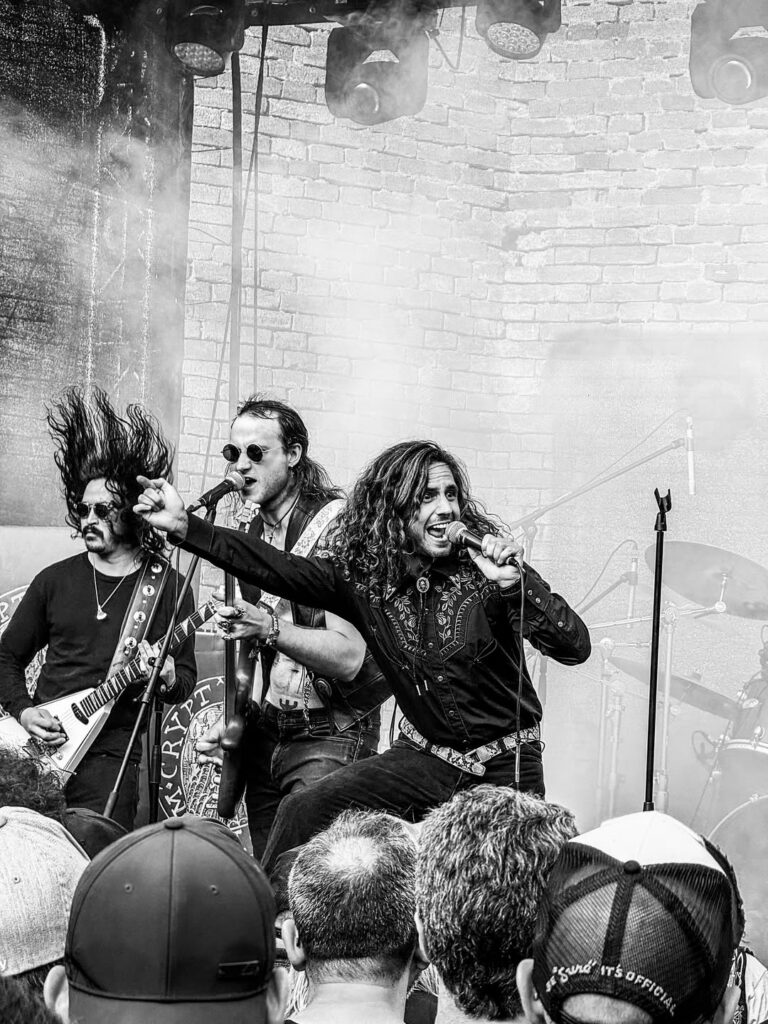 A metal band with two vocalists plays for a crown in front of a fog machine