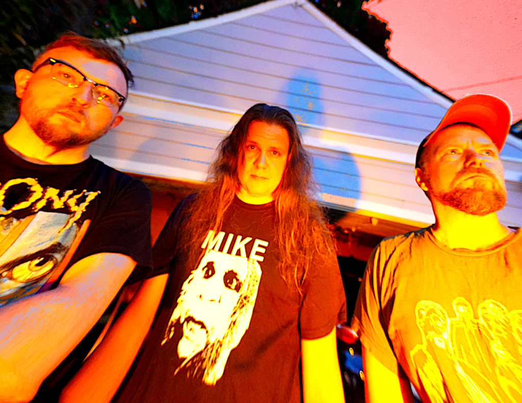 Three dudes standing in the evening light near a garage