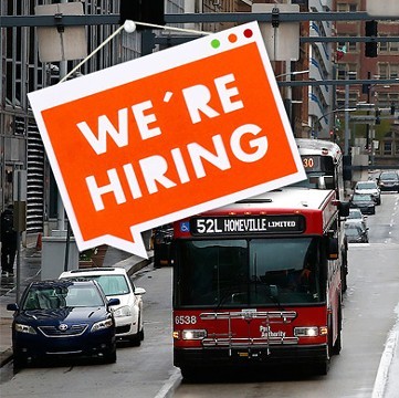 A red bus and a sign that says "now hiring"