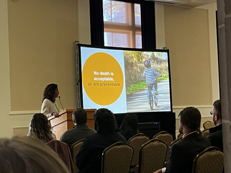 A woman gives a PowerPoint presentation to a ballroom full of transit enthusiasts