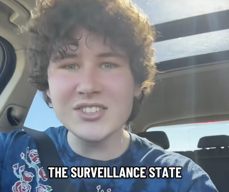 A young person with curly hair sits in a car speaking into the camera above the words THE SURVEILLANCE STATE