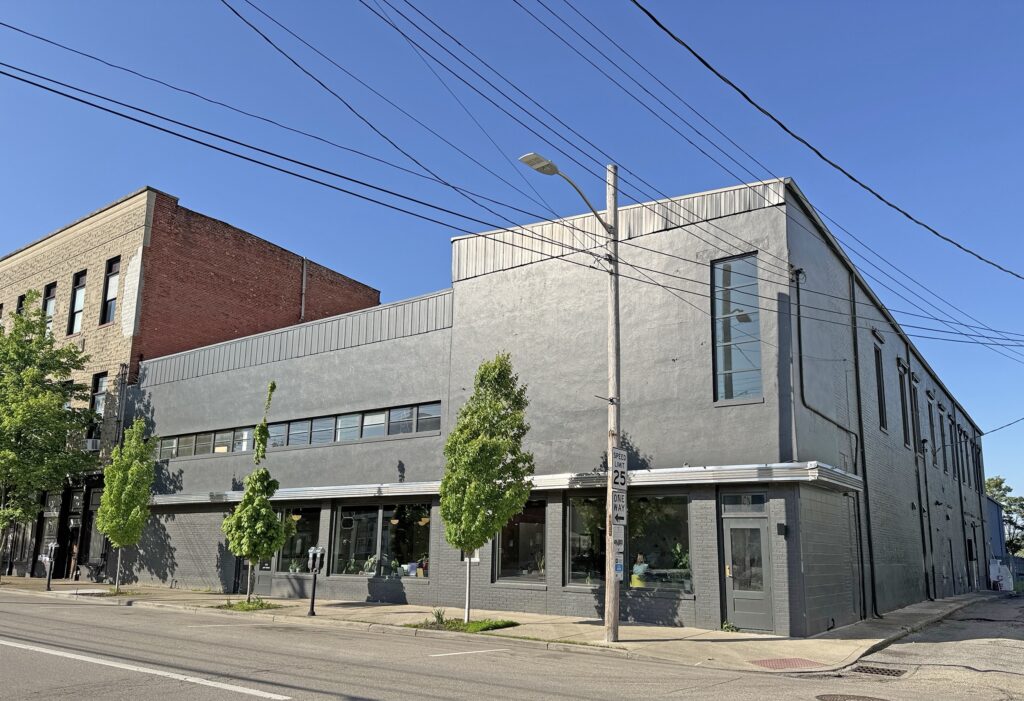 A painted brick building with a large modern second story